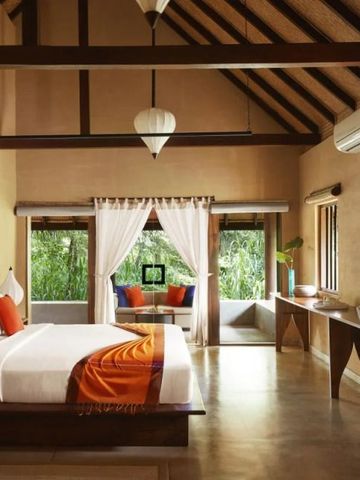 Luxuriöses Schlafzimmer mit Holzbalken und großen Fenstern mit Blick auf die Natur
