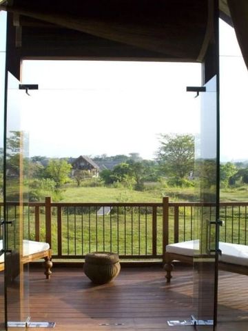 Balkon mit Glasabtrennung und Aussicht auf grüne Landschaft