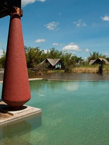 Infinity-Pool mit Ausblick auf umgebende Natur und Hütten