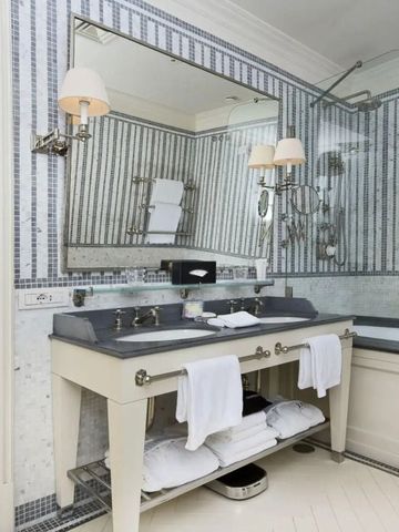 Stilvolles Badezimmer mit eleganten Mosaikfliesen und Doppelwaschbecken