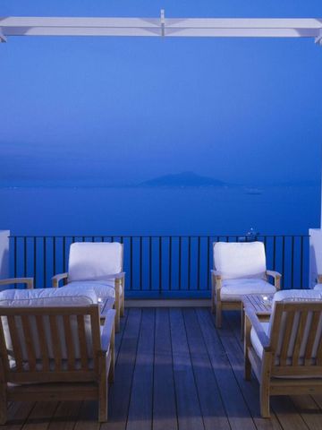 Terrasse mit Sitzgelegenheiten und atemberaubendem Blick auf das Meer bei Abenddämmerung