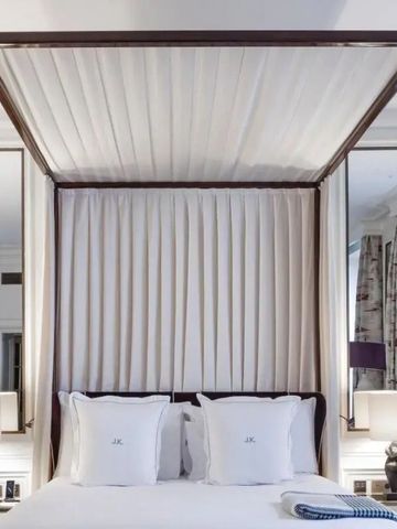 Elegantes Schlafzimmer mit Himmelbett und hochwertigen Textilien