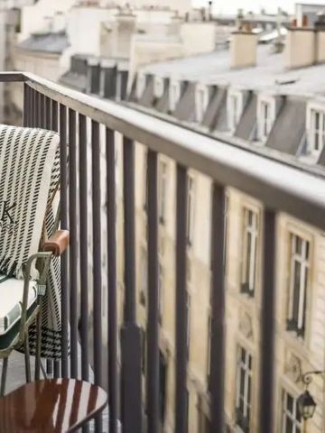 Balkon mit Ausblick auf Pariser Gebäude und eleganter Bestuhlung