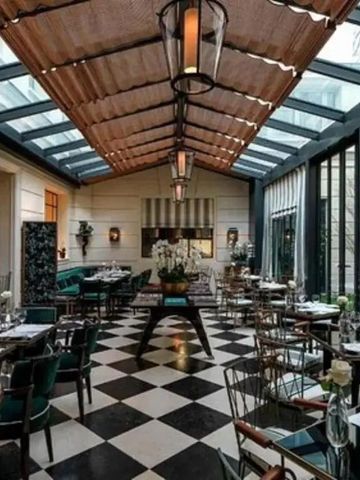 Elegantes Hotelrestaurant mit Glasdach und stilvoller Einrichtung