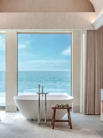 Luxuriöses Badezimmer mit freistehender Badewanne und Meerblick