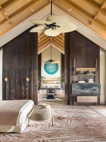 Luxuriöses Schlafzimmer im Joali Maldives Resort mit hoher Decke und Kunstwerken