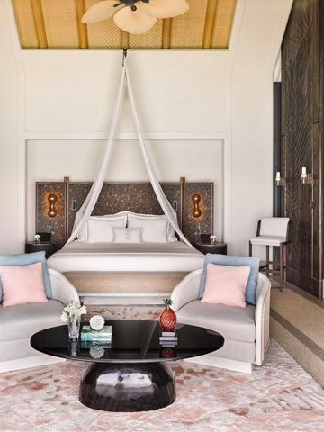 Schlafzimmer mit Baldachinbett und stilvollen Möbeln im Joali Maldives Resort