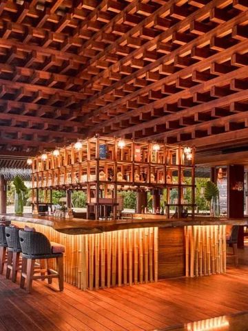 Elegante Bar mit Holzdach und Lounge-Sitzen im Joali Maldives Resort
