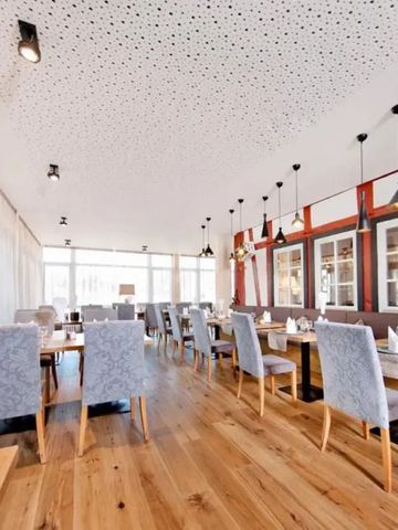 Helles Restaurant mit eleganter Dekoration und großen Fenstern