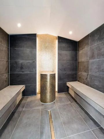 Moderne Dampfbad-Lounge mit dunklen Fliesen und stilvoller Beleuchtung