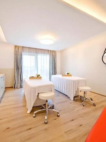 Heller Massageraum mit zwei Behandlungstischen und stilvollem Dekor