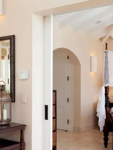 Elegantes Schlafzimmer mit Himmelbett und dezenten Dekorationen aus Holz