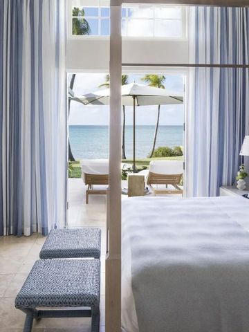 Helles Schlafzimmer mit direktem Zugang zum Meer und modernen blauen Akzenten