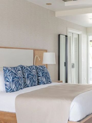 Helles Zimmer mit Doppelbett und eleganter Dekoration in neutralen Farben