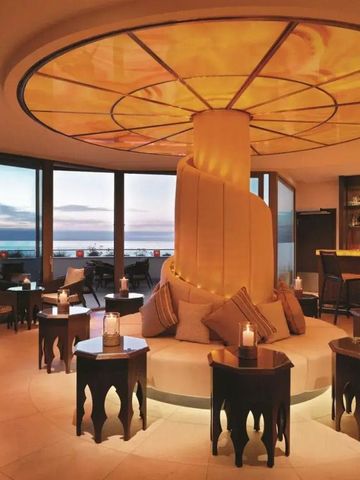 Gemütliche Bar-Lounge mit warmem Licht und Meerblick bei Sonnenuntergang