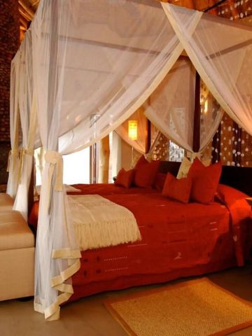 Exquisites Himmelbett mit roten Akzenten und weichen Stoffen