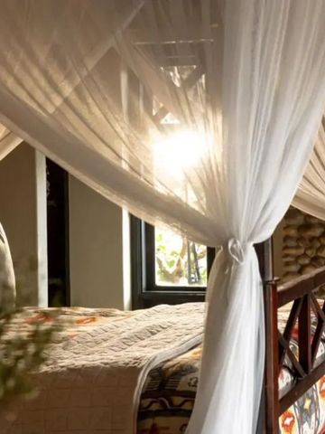 Sonnenlicht strömt durch die Vorhänge eines luxuriösen Schlafzimmers