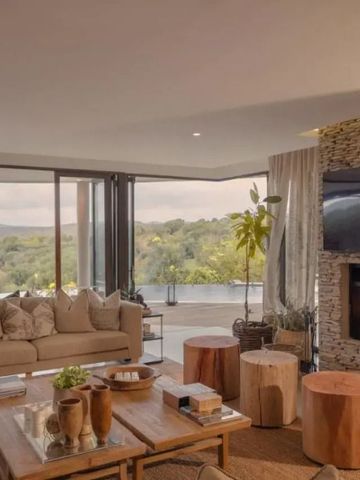 Luxuriöses Wohnzimmer mit Kamin und Panoramafenstern.