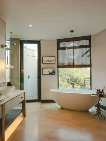 Modernes Badezimmer mit freistehender Wanne und großen Fenstern.