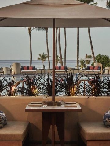 Terrasse mit Sitzgelegenheiten und Meerblick am Pool bei Sonnenuntergang