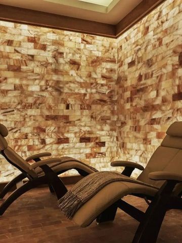 Gemütlicher Spa-Raum mit entspannenden Liegen und Wänden aus Himalaya-Salzsteinen.