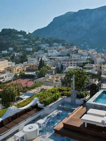 Hotelterrasse mit Pool und panoramischer Aussicht auf die Stadt und Berge.