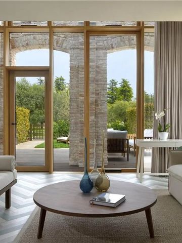 Modernes Wohnzimmer mit großen Glasfenstern und Blick auf die Terrasse