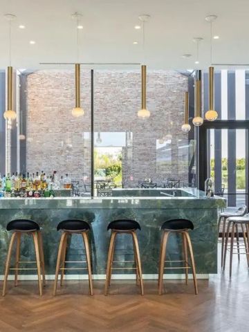 Moderne Bar mit eleganten Holzstühlen und stilvoller Beleuchtung