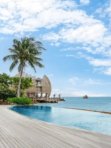 Infinity-Pool mit Meerblick umgeben von Palmen und blühendem Himmel
