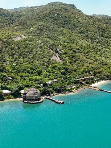 Luftaufnahme von tropischer Landschaft mit Villen und klarem blauem Wasser