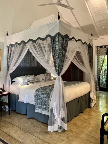 Luxuriöses Zimmer mit stilvollem Himmelbett und Gartenblick