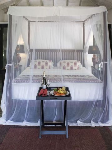 Geräumiges Schlafzimmer mit modernem Himmelbett aus Holz