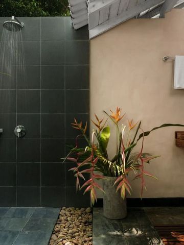 Außendusche mit natürlichen Pflanzen und moderner Gestaltung