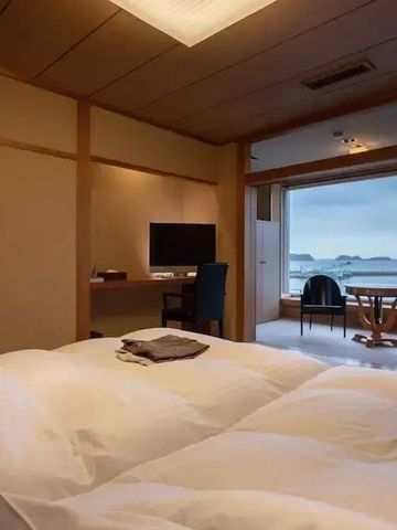 Modernes Zimmer mit Betten und Schreibtisch mit Meerblick