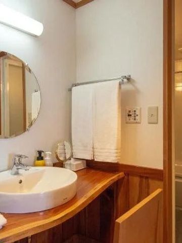 Modernes Badezimmer mit rundem Waschbecken und Holzdetails