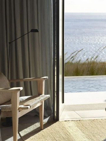 Eleganter Lounge-Bereich mit Blick auf das Meer durch eine offene Verandatür