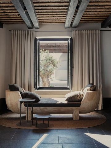 Gemütlicher Ruhebereich mit Tagesbett und offenem Fenster zu einem Innenhof