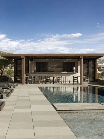 Moderner Poolbereich mit Bar und Sonnenliegen unter blauem Himmel