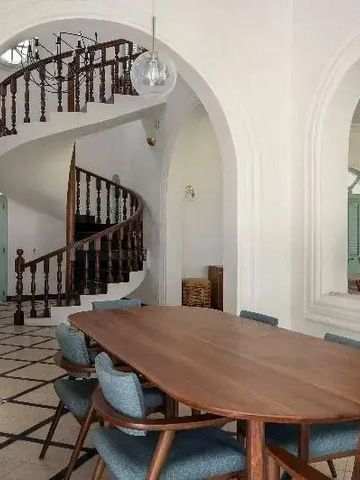 Essbereich mit einem Tisch vor einer geschwungenen Treppe