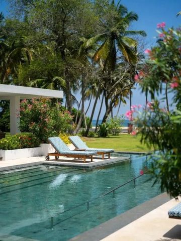 Pool mit Liegen umgeben von Palmen und blühenden Pflanzen