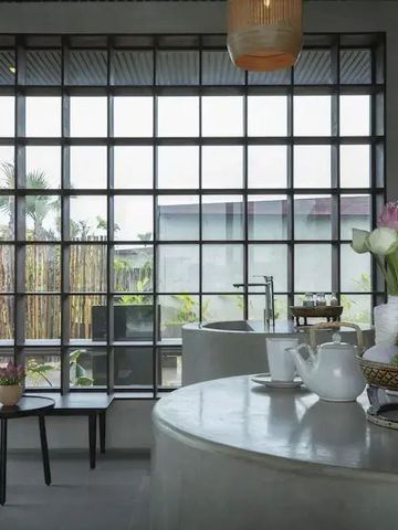 Heller Lounge-Bereich mit großen Fenstern und stilvollem Dekor