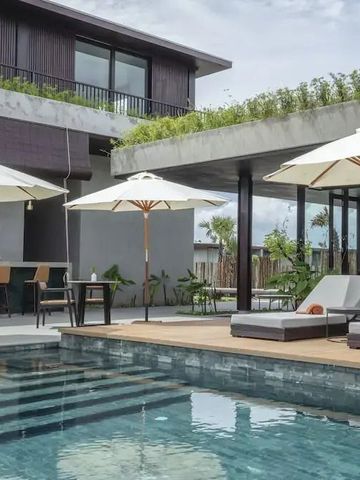 Moderner Poolbereich mit Liegen und Sonnenschirmen vor einer Villa