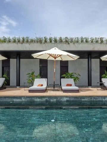 Pool mit Sonnenschirmen vor moderner Architektur und blauen Himmel