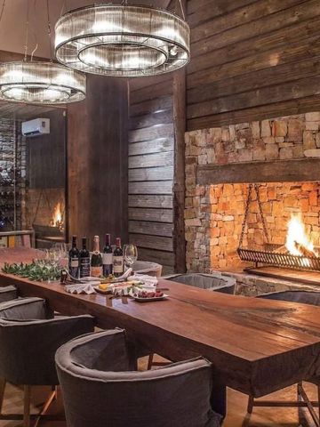 Einladender Essbereich mit Kamin und Weinauswahl im Kariega Game Reserve