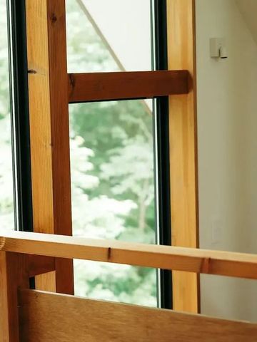 Großes Fenster mit Blick ins Grüne im modernen Raum mit Holzdetails