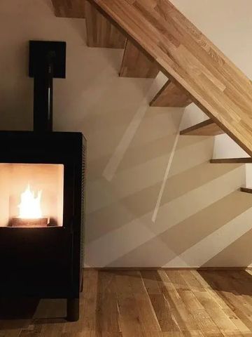 Holzofen unter einer Treppe aus Holz in einer gemütlichen Ecke