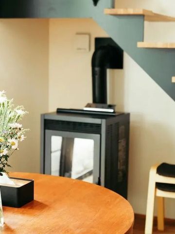 Gemütliche Ecke mit Tisch, Blumen und modernem Kamin