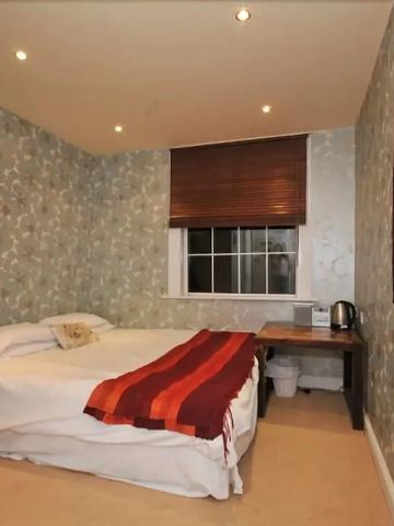 Gemütliches Schlafzimmer mit Doppelbett und floralem Tapetendesign