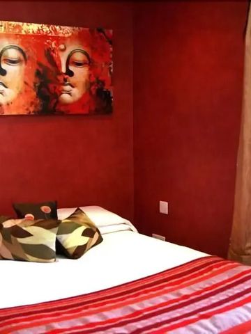 Elegantes Schlafzimmer in Rot mit modernem Kunstwerk an der Wand