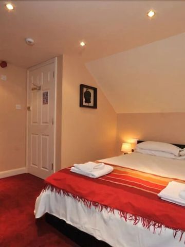 Modernes Zimmer mit Doppelbett und warmen Lichtakzenten